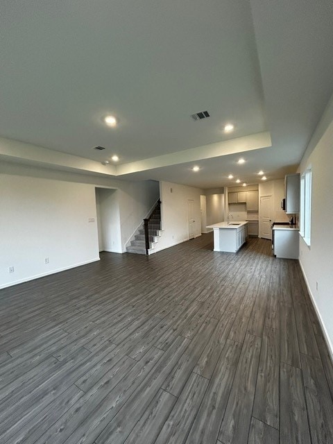 1127 Buffalo Run, Tomball, TX 77375 - unfurnished living room featuring dark wood finished floors, stairway, and recessed lighting