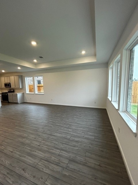 1127 Buffalo Run, Tomball, TX 77375 - unfurnished living room featuring a tray ceiling, recessed lighting, and dark wood-style floors