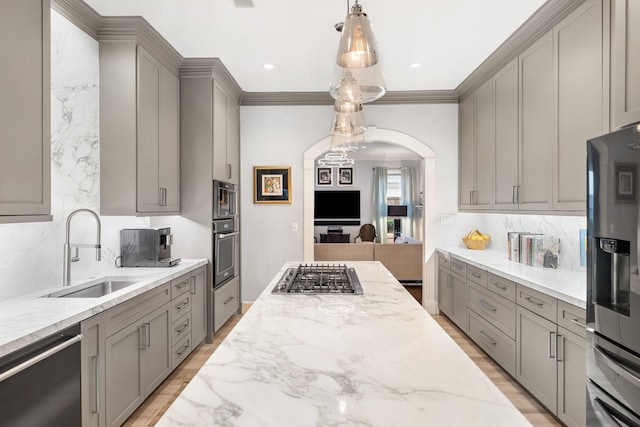 38 Hackberry Ln, Houston, TX 77027 - kitchen featuring gray cabinetry, appliances with stainless steel finishes, decorative backsplash, light stone counters, and arched walkways