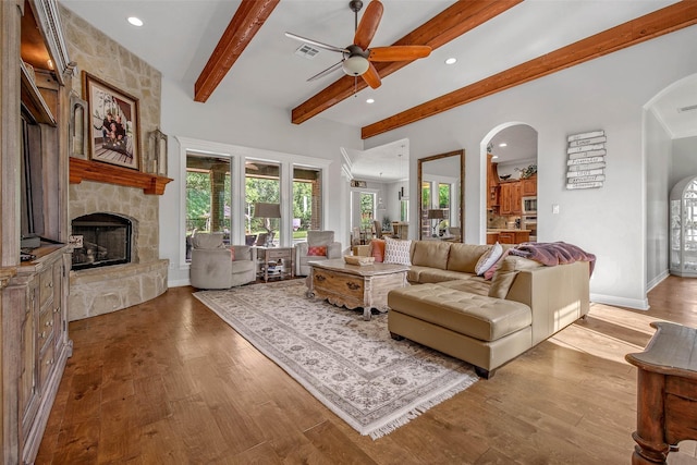 17817 Ranch House Rd, College Station, TX 77845 - living area featuring arched walkways, beam ceiling, a ceiling fan, a fireplace, and plenty of natural light