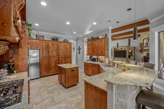 17817 Ranch House Rd, College Station, TX 77845 - kitchen with stainless steel appliances, a peninsula, a breakfast bar, light stone countertops, and brown cabinetry