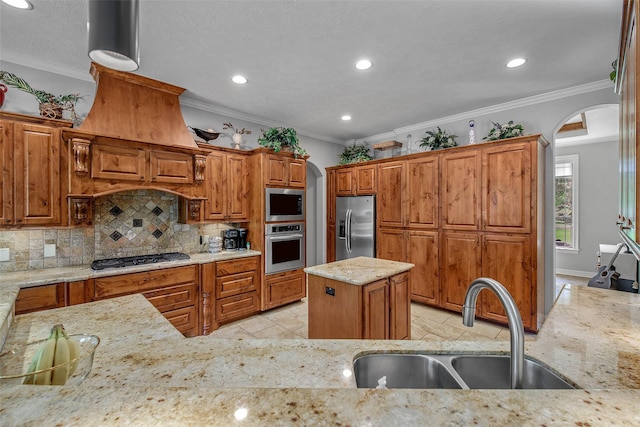 17817 Ranch House Rd, College Station, TX 77845 - kitchen featuring arched walkways, stainless steel appliances, light stone countertops, decorative backsplash, and brown cabinets