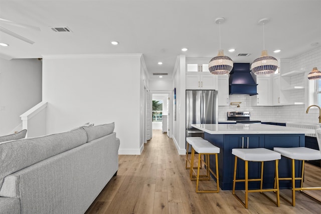 210 Galveston St, Crystal Beach, TX 77650 - kitchen with appliances with stainless steel finishes, premium range hood, a kitchen breakfast bar, open floor plan, and white cabinetry