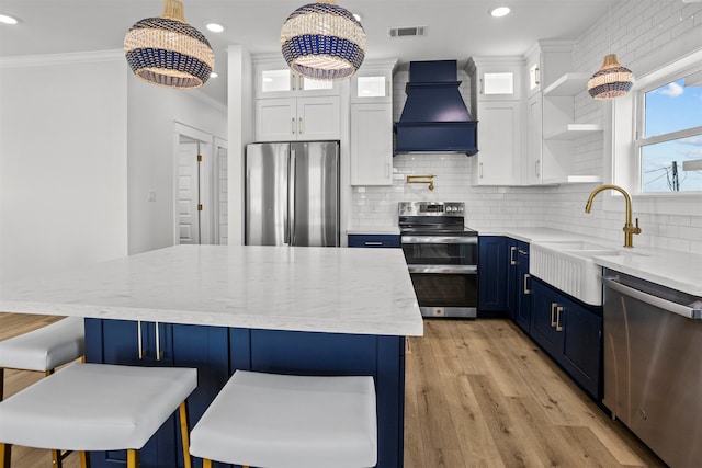 210 Galveston St, Crystal Beach, TX 77650 - kitchen with stainless steel appliances, custom exhaust hood, blue cabinets, crown molding, and open shelves
