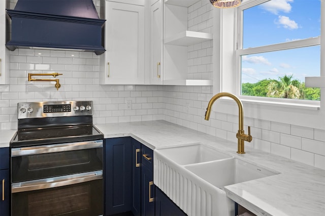 210 Galveston St, Crystal Beach, TX 77650 - kitchen featuring double oven range, blue cabinetry, exhaust hood, open shelves, and healthy amount of natural light