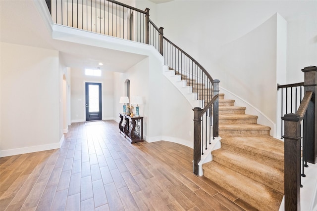 21018 Cypress Creek View Ct, Humble, TX 77338 - entrance foyer featuring a towering ceiling, stairs, wood finished floors, and arched walkways