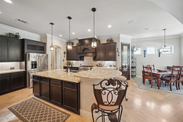 5924 Oak Leaf Ct, Conroe, TX 77304 - kitchen with appliances with stainless steel finishes, tasteful backsplash, an island with sink, pendant lighting, and arched walkways