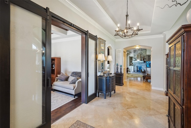 5924 Oak Leaf Ct, Conroe, TX 77304 - foyer entrance featuring arched walkways, a barn door, a chandelier, a raised ceiling, and crown molding