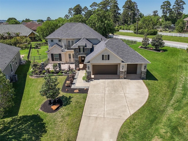 5924 Oak Leaf Ct, Conroe, TX 77304 - french country style house with stone siding, driveway, a garage, and roof with shingles