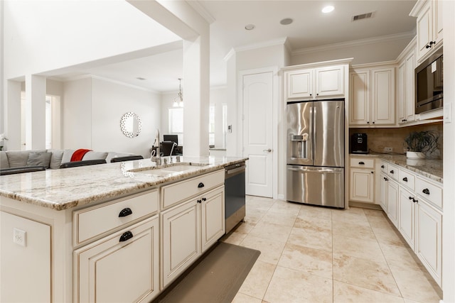 28423 Tanner Crossing Ln, Katy, TX 77494 - kitchen with stainless steel appliances, cream cabinetry, open floor plan, light stone countertops, and ornamental molding