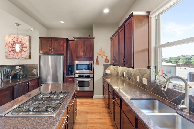 5122 Lillian St, Houston, TX 77007 - kitchen with appliances with stainless steel finishes, light wood finished floors, recessed lighting, dark stone counters, and pendant lighting