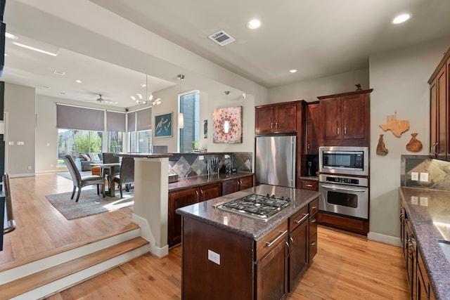 5122 Lillian St, Houston, TX 77007 - kitchen featuring stainless steel appliances, open floor plan, light wood-type flooring, recessed lighting, and dark stone counters