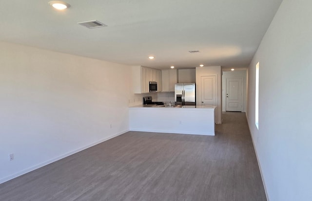 3005 Blue Gem Ct, Katy, TX 77493 - kitchen with stainless steel refrigerator with ice dispenser, dark wood finished floors, a peninsula, range, and recessed lighting