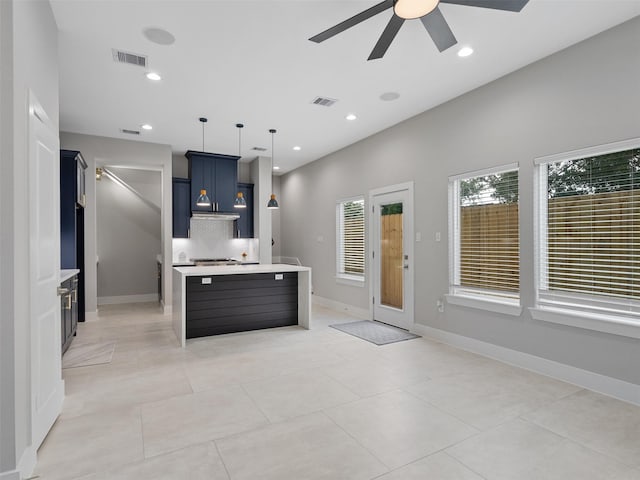 825 Paul Quinn St Unit E, Houston, TX 77091 - kitchen with ceiling fan, light countertops, blue cabinetry, a kitchen island with sink, and decorative light fixtures