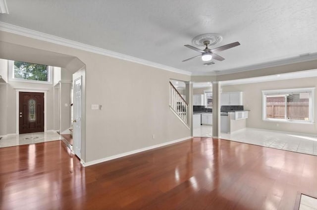 9110 Memorial Creek Dr, Spring, TX 77379 - unfurnished living room featuring ceiling fan, wood finished floors, stairs, crown molding, and a textured ceiling