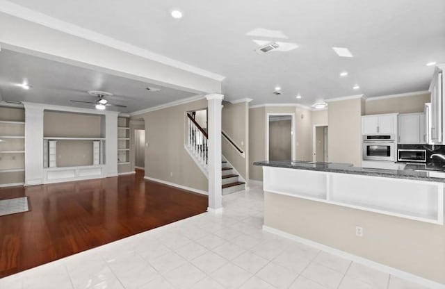 9110 Memorial Creek Dr, Spring, TX 77379 - kitchen with stainless steel oven, decorative columns, ornamental molding, recessed lighting, and white cabinets