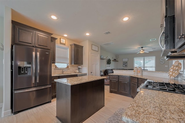 9119 Anna St, Needville, TX 77461 - kitchen with appliances with stainless steel finishes, dark brown cabinetry, tasteful backsplash, a ceiling fan, and recessed lighting