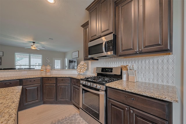 9119 Anna St, Needville, TX 77461 - kitchen with stainless steel appliances, dark brown cabinetry, ceiling fan, and decorative backsplash