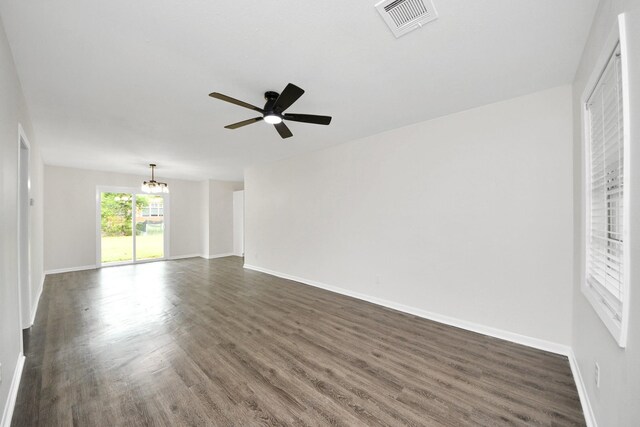 9611 Bertwood St, Houston, TX 77016 - spare room with a chandelier, ceiling fan, and dark wood-type flooring