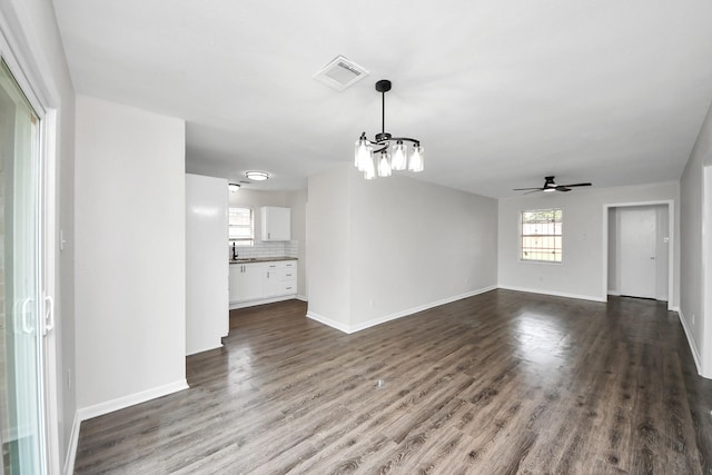 9611 Bertwood St, Houston, TX 77016 - unfurnished living room featuring a chandelier, ceiling fan, and dark wood-style flooring