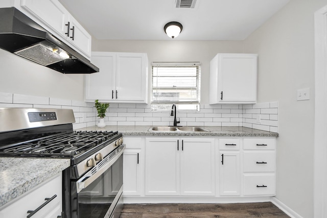 9611 Bertwood St, Houston, TX 77016 - kitchen featuring stainless steel gas range, range hood, tasteful backsplash, and white cabinets