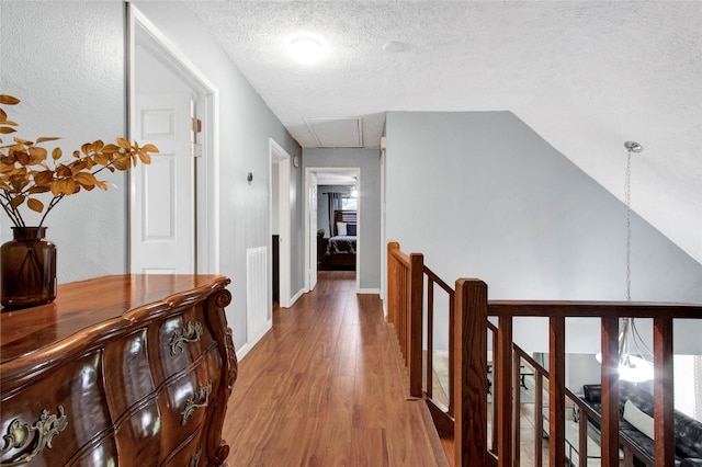 21426 Park York Dr, Katy, TX 77450 - hallway with attic access, an upstairs landing, wood finished floors, a textured ceiling, and lofted ceiling