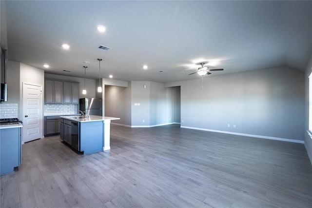 1202 Oak Barrel Run, Richmond, TX 77406 - kitchen featuring freestanding refrigerator, a ceiling fan, recessed lighting, light wood-style floors, and an island with sink