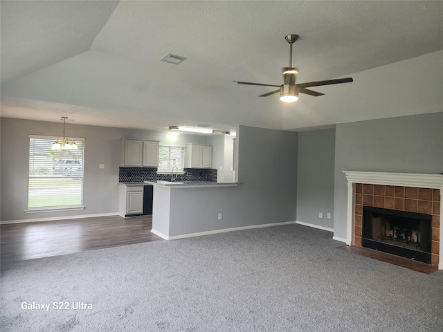 14119 Falling Elm Ln, Houston, TX 77015 - unfurnished living room with dark carpet, a fireplace, a ceiling fan, and vaulted ceiling