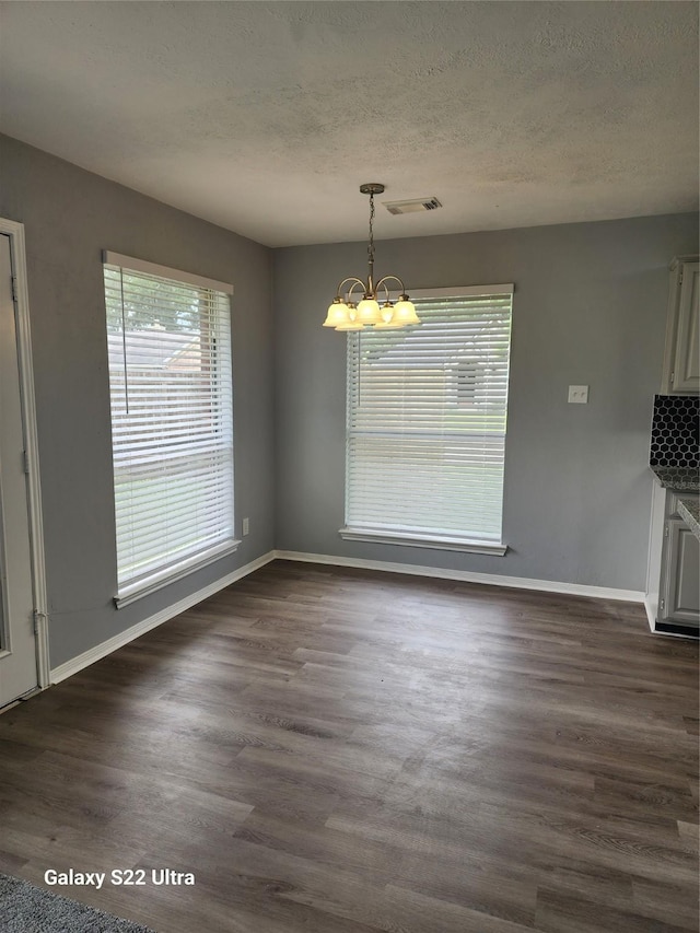 14119 Falling Elm Ln, Houston, TX 77015 - unfurnished dining area with a chandelier, a textured ceiling, and dark wood finished floors