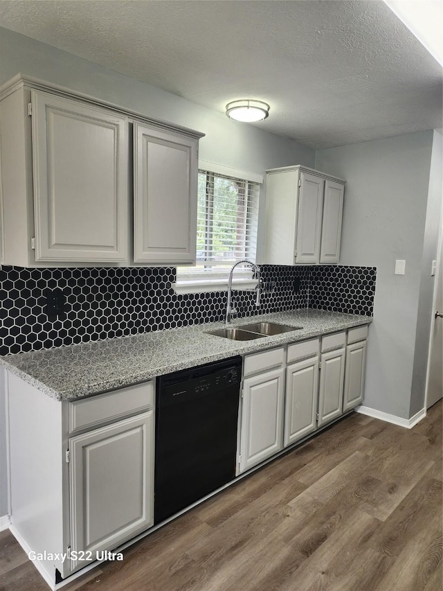 14119 Falling Elm Ln, Houston, TX 77015 - kitchen featuring black dishwasher, dark wood-style flooring, tasteful backsplash, a textured ceiling, and light stone counters