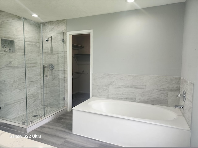 14119 Falling Elm Ln, Houston, TX 77015 - bathroom featuring a garden tub, a stall shower, a walk in closet, wood finished floors, and recessed lighting