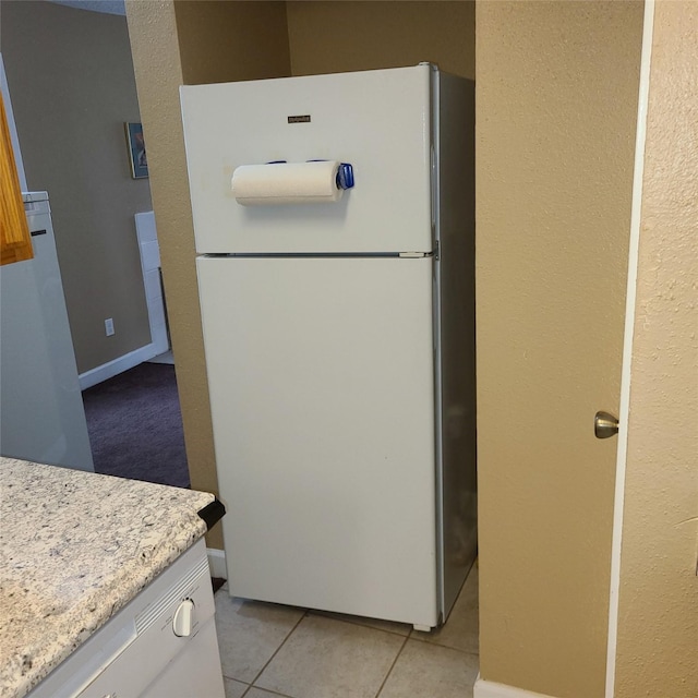 2011 Spenwick Dr Unit 220, Houston, TX 77055 - kitchen with freestanding refrigerator, light tile patterned floors, white cabinets, and light stone counters