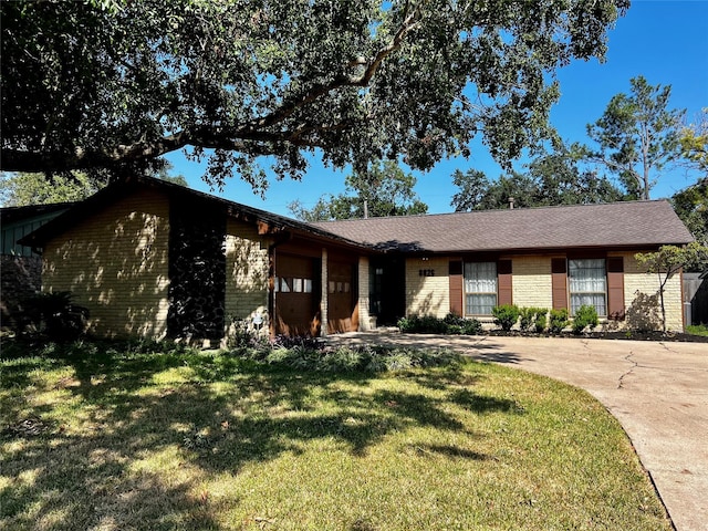 8826 Tanager St, Houston, TX 77036 - ranch-style home featuring brick siding, concrete driveway, a garage, and a front lawn