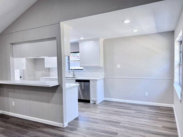 8826 Tanager St, Houston, TX 77036 - kitchen with dishwasher, white cabinets, light wood finished floors, decorative backsplash, and light countertops