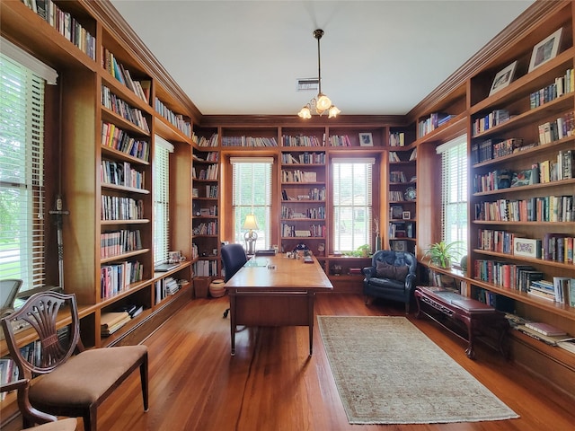 1406 Key St, Brenham, TX 77833 - home office featuring wall of books, crown molding, wood finished floors, built in features, and plenty of natural light