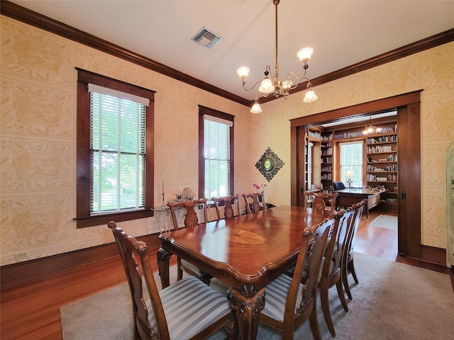 1406 Key St, Brenham, TX 77833 - dining area featuring wood finished floors, a chandelier, and crown molding