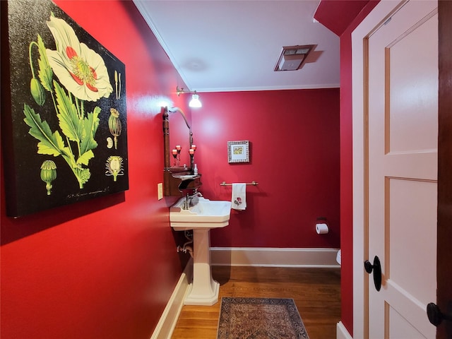 1406 Key St, Brenham, TX 77833 - half bathroom with wood finished floors and ornamental molding