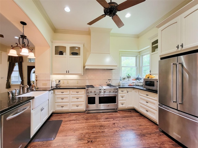 1406 Key St, Brenham, TX 77833 - kitchen with premium appliances, custom exhaust hood, ceiling fan, crown molding, and glass insert cabinets