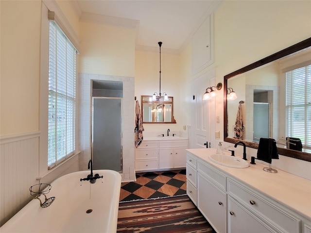1406 Key St, Brenham, TX 77833 - full bathroom featuring a stall shower, two vanities, a freestanding bath, a chandelier, and a wainscoted wall