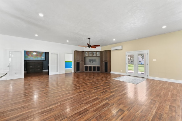 43919 Austin Branch Rd, Hempstead, TX 77445 - unfurnished living room featuring a wall mounted AC, dark wood finished floors, ceiling fan, recessed lighting, and french doors