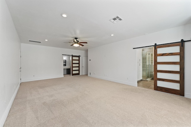 43919 Austin Branch Rd, Hempstead, TX 77445 - spare room with a barn door, light colored carpet, a ceiling fan, and recessed lighting