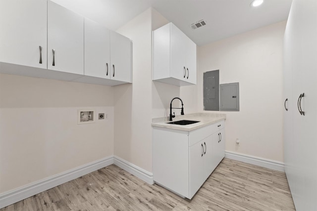 43919 Austin Branch Rd, Hempstead, TX 77445 - laundry area featuring electric panel, light wood-style flooring, electric dryer hookup, cabinet space, and hookup for a washing machine