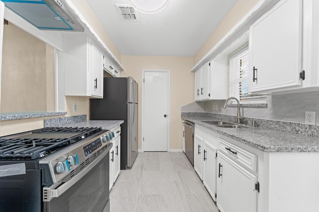 9403 Rentur Dr, Houston, TX 77031 - kitchen with appliances with stainless steel finishes, extractor fan, white cabinets, light marble finish flooring, and light stone countertops