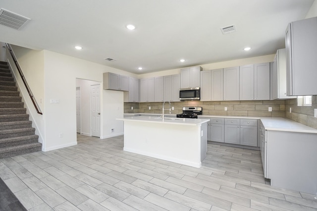 2807 Pine Estate Ln, Houston, TX 77014 - kitchen featuring appliances with stainless steel finishes, tasteful backsplash, gray cabinetry, light countertops, and recessed lighting