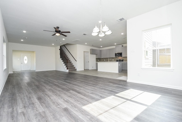 2807 Pine Estate Ln, Houston, TX 77014 - unfurnished living room featuring stairway, recessed lighting, ceiling fan, light wood-type flooring, and a chandelier