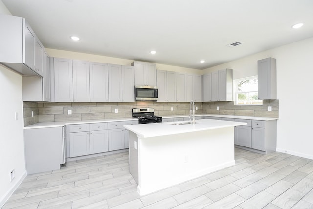 2807 Pine Estate Ln, Houston, TX 77014 - kitchen with stainless steel appliances, gray cabinetry, decorative backsplash, light countertops, and recessed lighting