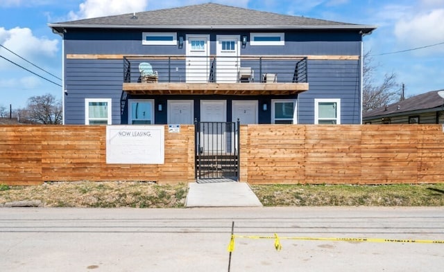 3801 Anita St, Houston, TX 77004 - view of front facade with a balcony, a fenced front yard, and a gate