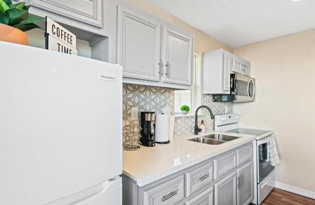 3801 Anita St, Houston, TX 77004 - kitchen with white appliances, decorative backsplash, light countertops, and dark wood finished floors