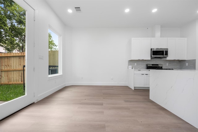 6815 Paris St, Houston, TX 77021 - kitchen with appliances with stainless steel finishes, white cabinetry, decorative backsplash, light stone countertops, and recessed lighting