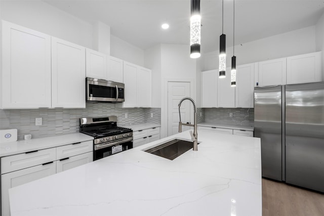 6815 Paris St, Houston, TX 77021 - kitchen featuring stainless steel appliances, backsplash, pendant lighting, light stone counters, and white cabinets